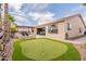 Beautiful backyard featuring a putting green, outdoor kitchen and seating area, perfect for entertaining at 16781 W Northampton Rd, Surprise, AZ 85374