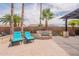 Resort-style backyard with loungers, waterfall feature, and lush palm trees at 16781 W Northampton Rd, Surprise, AZ 85374