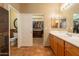 Spacious bathroom features walk-in closet, double mirrors, wooden cabinets and tile floors at 16781 W Northampton Rd, Surprise, AZ 85374