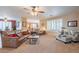Bright living room with plush carpeting, plantation shutters, and comfortable seating at 16781 W Northampton Rd, Surprise, AZ 85374