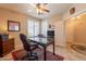 Bright office space features plantation shutters, a ceiling fan, and a desk with a leather desk chair at 16781 W Northampton Rd, Surprise, AZ 85374