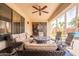 Relax on the patio with a ceiling fan, comfortable sofa, and a mosaic fire pit table at 16781 W Northampton Rd, Surprise, AZ 85374