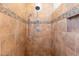 Modern shower features neutral toned tile and a built-in soap niche at 16781 W Northampton Rd, Surprise, AZ 85374