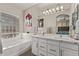 Bathroom features double vanity sinks, large mirror, soaking tub, and decorative paintings on the wall at 16803 N 49Th Way, Scottsdale, AZ 85254