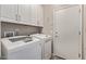 Well-equipped laundry room with modern washer and dryer, upper cabinets, and a convenient utility sink at 16803 N 49Th Way, Scottsdale, AZ 85254