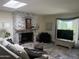 Bright living room with a stone fireplace, skylight, and large windows, creating a welcoming space at 1725 N Date -- # 8, Mesa, AZ 85201