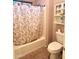 Bathroom features a shower-tub combo with a floral curtain, plus a toilet and shelving at 17257 W Papago St, Goodyear, AZ 85338