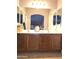 Bathroom featuring a double sink vanity with wood cabinetry and a large mirror at 17257 W Papago St, Goodyear, AZ 85338