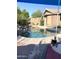 Backyard swimming pool with rock features, surrounded by mature trees and a shaded patio at 17257 W Papago St, Goodyear, AZ 85338