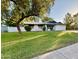 Inviting single-story home with a lush lawn and mature shade tree in the front yard at 1742 W Butler Dr, Phoenix, AZ 85021