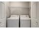Convenient laundry room with washer, dryer, and overhead shelving behind double doors at 20100 N 78Th Pl # 2019, Scottsdale, AZ 85255