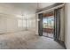 Bright and airy living room featuring neutral carpet, ceiling fan, and access to a private balcony at 20100 N 78Th Pl # 2019, Scottsdale, AZ 85255