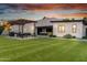 Sprawling backyard with synthetic lawn, outdoor kitchen, and covered patio perfect for entertaining at 2215 N 38Th Way, Phoenix, AZ 85008