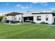 Expansive backyard with artificial turf, modern pergola, and covered patio seating area at 2215 N 38Th Way, Phoenix, AZ 85008