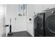 Laundry room with black tile floors, tile backsplash, and modern, matching washer and dryer at 2215 N 38Th Way, Phoenix, AZ 85008