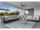 Covered outdoor patio with a large seating area, modern ceiling fan, and an outdoor rug at 2215 N 38Th Way, Phoenix, AZ 85008