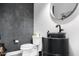 Unique powder room featuring concrete accent wall, vessel sink, and a modern, round mirror at 2215 N 38Th Way, Phoenix, AZ 85008