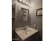 Comfortable bathroom featuring a vanity with sink, mirror, updated lighting, and decorative wall art at 2233 E Behrend Dr # 121, Phoenix, AZ 85024
