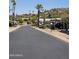 A quiet community street lined with homes, palm trees, desert vegetation, and mountain views at 2233 E Behrend Dr # 121, Phoenix, AZ 85024