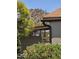 Home exterior with desert landscape, mature trees, and carport, blending with the natural surroundings at 2233 E Behrend Dr # 121, Phoenix, AZ 85024