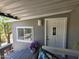 View of front door, front window, flower arrangement, and cozy, covered porch area at 2233 E Behrend Dr # 121, Phoenix, AZ 85024