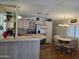 Bright kitchen flows into dining area, featuring white cabinetry, breakfast bar, and stainless steel refrigerator at 2233 E Behrend Dr # 121, Phoenix, AZ 85024
