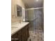 The bathroom has a double sink vanity with a glass enclosed shower with tiled walls at 2233 E Behrend Dr # 17, Phoenix, AZ 85024