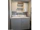 Bright laundry area with white washer and dryer and overhead shelving at 2233 E Behrend Dr # 17, Phoenix, AZ 85024