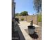 This charming patio has stone pavers, decorative rock, chairs, and a stucco wall at 2233 E Behrend Dr # 17, Phoenix, AZ 85024