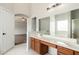 Bathroom featuring a double sink vanity with wood cabinets, white tile flooring, and bathtub shower at 22966 W Hopi St, Buckeye, AZ 85326