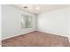 This carpeted bedroom features a window, ceiling fan and white walls, creating a bright space at 22966 W Hopi St, Buckeye, AZ 85326