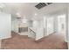 Hallway featuring carpeted floors, a staircase with wood railings, and access to other rooms at 22966 W Hopi St, Buckeye, AZ 85326