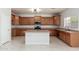 Spacious kitchen featuring wooden cabinets, an island, and stainless-steel appliances at 22966 W Hopi St, Buckeye, AZ 85326