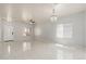 Open-concept living room with tile floors, ceiling fan, and modern chandelier at 22966 W Hopi St, Buckeye, AZ 85326