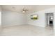 Living room with modern ceiling fan, large-format tile, and TV at 22966 W Hopi St, Buckeye, AZ 85326