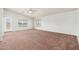 Open living room with carpet, two windows offering natural light, and a ceiling fan at 22966 W Hopi St, Buckeye, AZ 85326