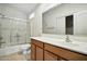 Bathroom with a tub and shower featuring glass doors, a vanity with wood cabinets and neutral tiling at 2402 E 5Th St # 1649, Tempe, AZ 85288