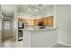 Kitchen with stainless steel appliances, wood cabinets, and an overhanging counter at 2402 E 5Th St # 1649, Tempe, AZ 85288