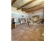 Open living room showcasing beamed ceilings, Saltillo tile floors, and a flood of natural light at 25449 W Pueblo Ave, Buckeye, AZ 85326