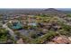 Aerial view of the community clubhouse, tennis courts, pool, and parking area surrounded by lush greenery at 3030 N Saranac --, Mesa, AZ 85207