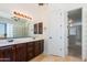 Bathroom with dual sinks, rich cabinetry, an oversized mirror and a walk-in closet/dressing area at 3030 N Saranac --, Mesa, AZ 85207