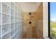 Bathroom shower featuring travertine tile, glass block, rainfall shower head, and a window at 3030 N Saranac --, Mesa, AZ 85207