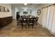 Open-concept dining area with hardwood-look tile floors and large wooden table at 30394 N Appalachian Trl, San Tan Valley, AZ 85143