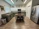 Modern kitchen with stainless steel appliances, island with bar seating, and white cabinets at 30394 N Appalachian Trl, San Tan Valley, AZ 85143