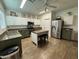Contemporary kitchen features stainless steel appliances, island with seating, and white cabinetry at 30394 N Appalachian Trl, San Tan Valley, AZ 85143