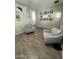 Cozy seating area with wood-look tile flooring and picture gallery wall creates a relaxing atmosphere at 30394 N Appalachian Trl, San Tan Valley, AZ 85143