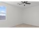 A bright bedroom with a black ceiling fan and a large window overlooking the backyard at 3105 W Romana Dr, Eloy, AZ 85131
