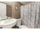 Compact bathroom featuring a floral shower curtain and pedestal sink at 48773 Cerezo Rd # 20, Maricopa, AZ 85139