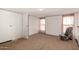 Light-filled bedroom with carpet floor, sliding door closet, and a chair near window at 48773 Cerezo Rd # 20, Maricopa, AZ 85139