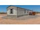 View of the side of the mobile home with gravel surround and blue skies at 48773 Cerezo Rd # 20, Maricopa, AZ 85139